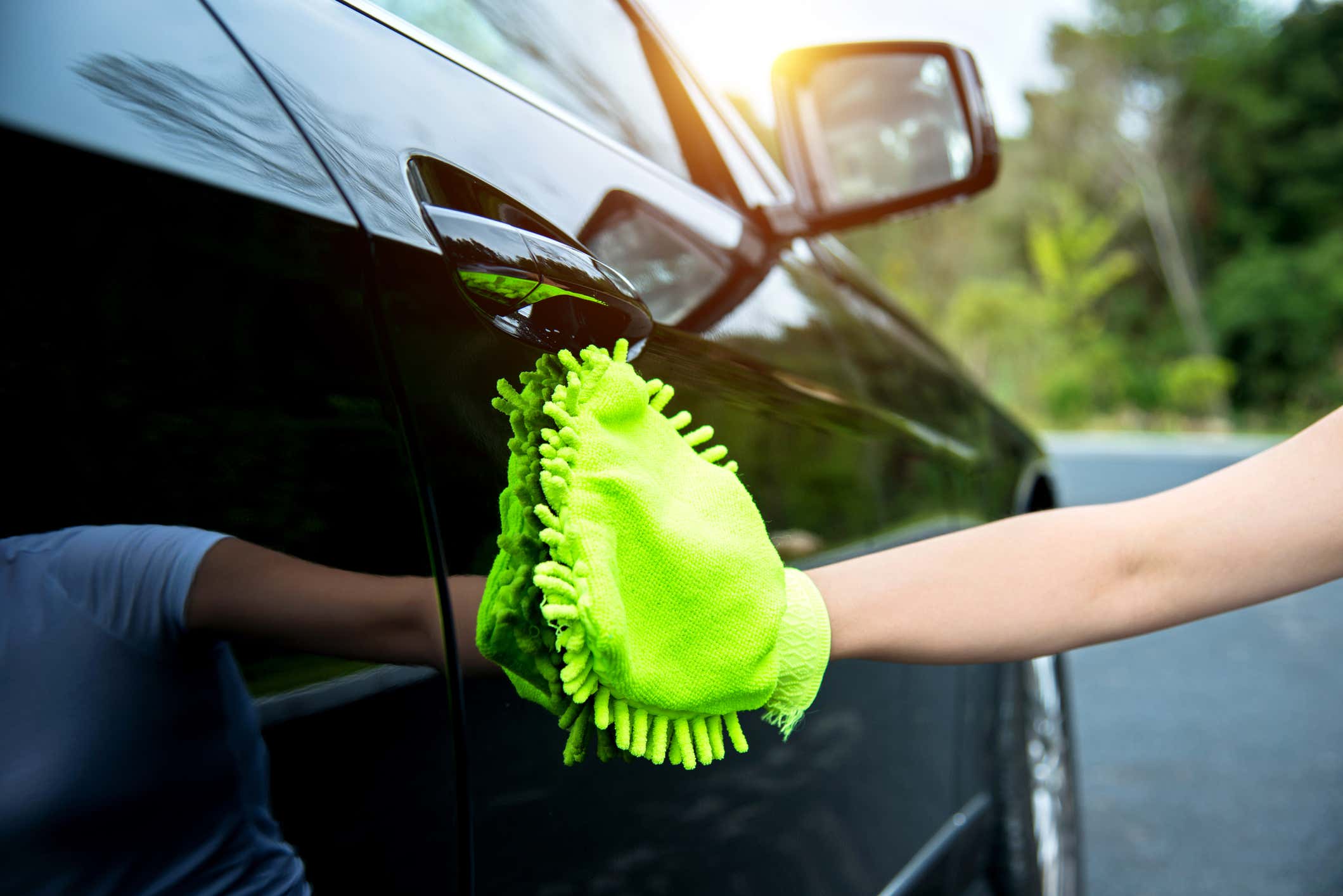 Woman hand polishing her black car 一个女人正在擦她的黑色汽车