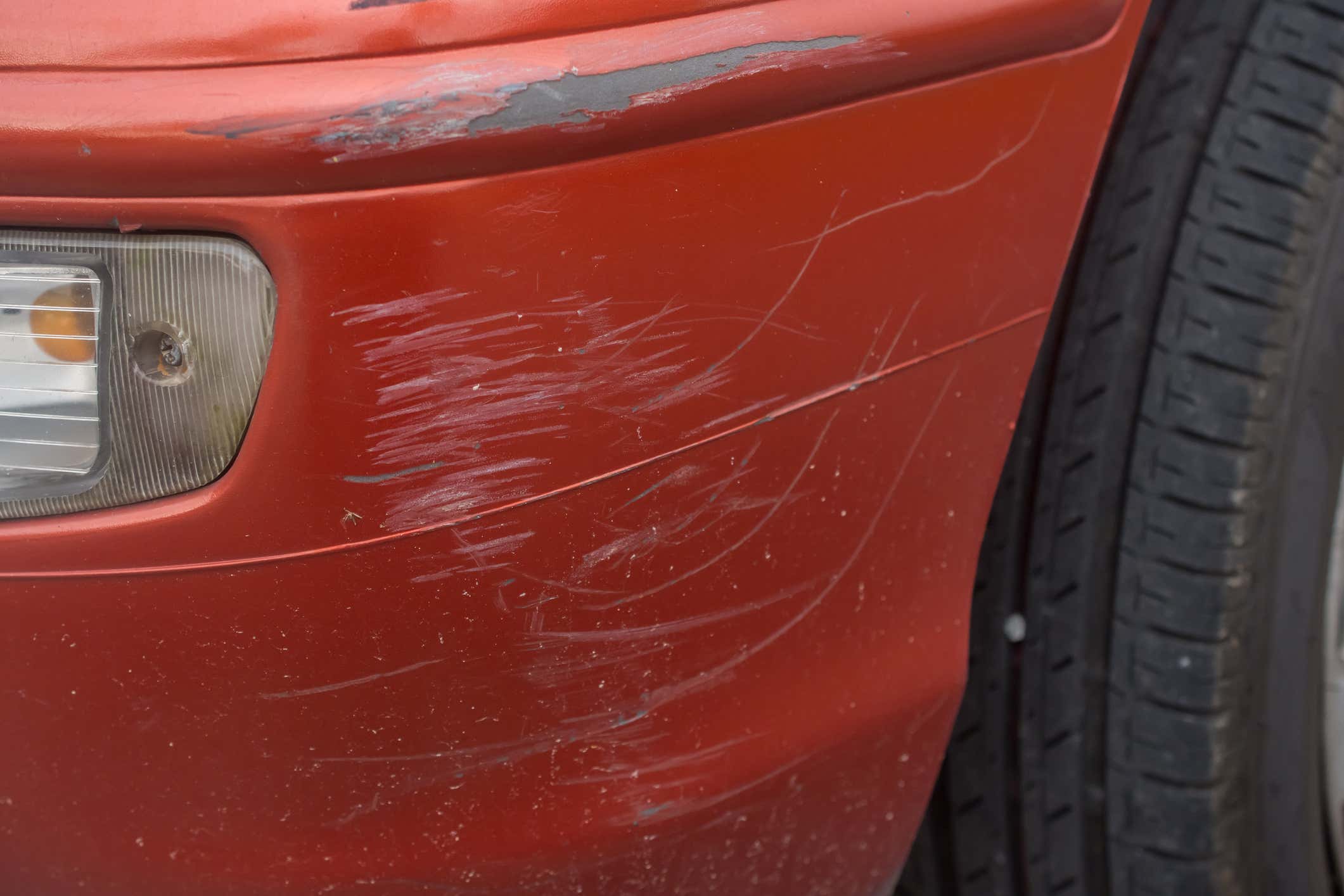 Red bumper car scratched with deep damage to the paint. 红色碰碰车的油漆有很深的破损。
