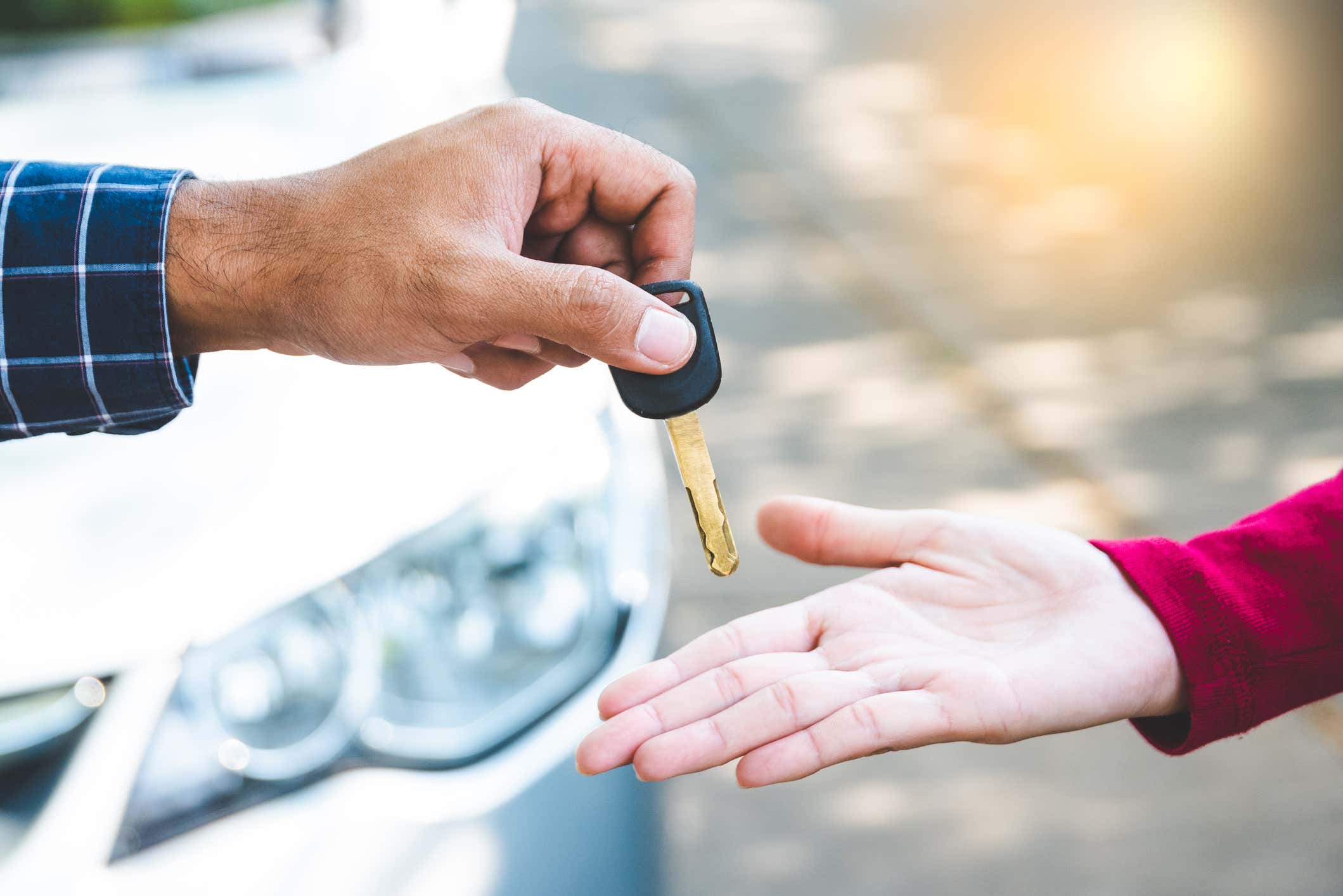 A man handing a woman some keys. 一个男人递给一个女人一些钥匙。