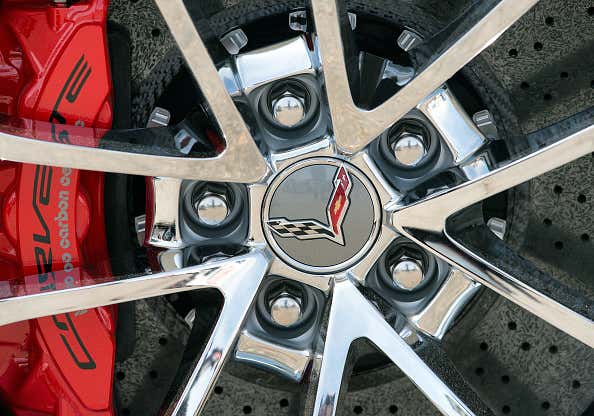 A close-up of a chrome Chevrolet Corvette wheel with red brake calipers. 一个特写的铬雪佛兰克尔维特车轮与红色制动卡钳。
