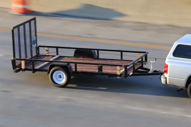 A car pulling a trailer on a highway. 在公路上拉拖车的汽车。