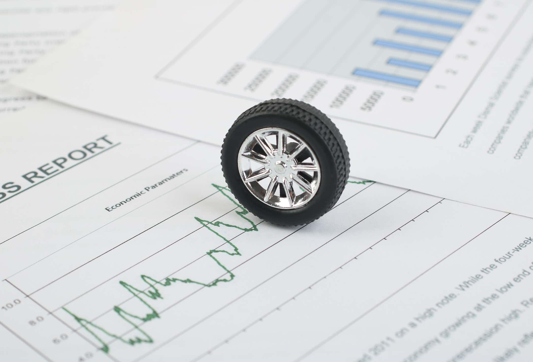 A toy tire sitting on a pile of papers. 一个玩具轮胎放在一堆文件上。