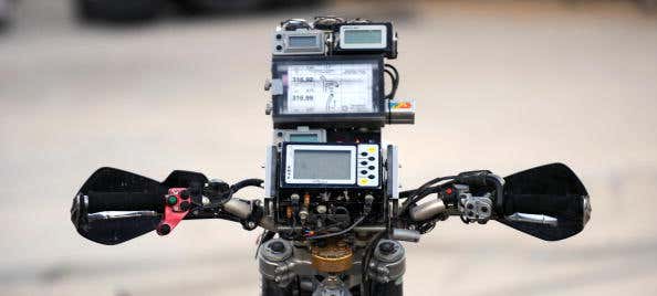 A GPS unit sits atop the gauge cluster of a motorcycle. GPS装置位于摩托车仪表组的顶部。