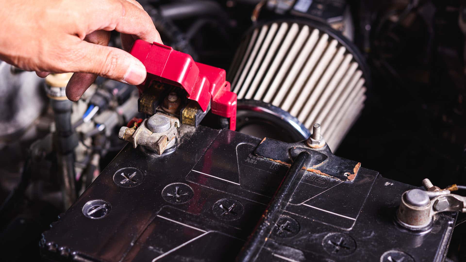 A positive battery terminal is covered by a red cap. 电池正极端有红帽盖。