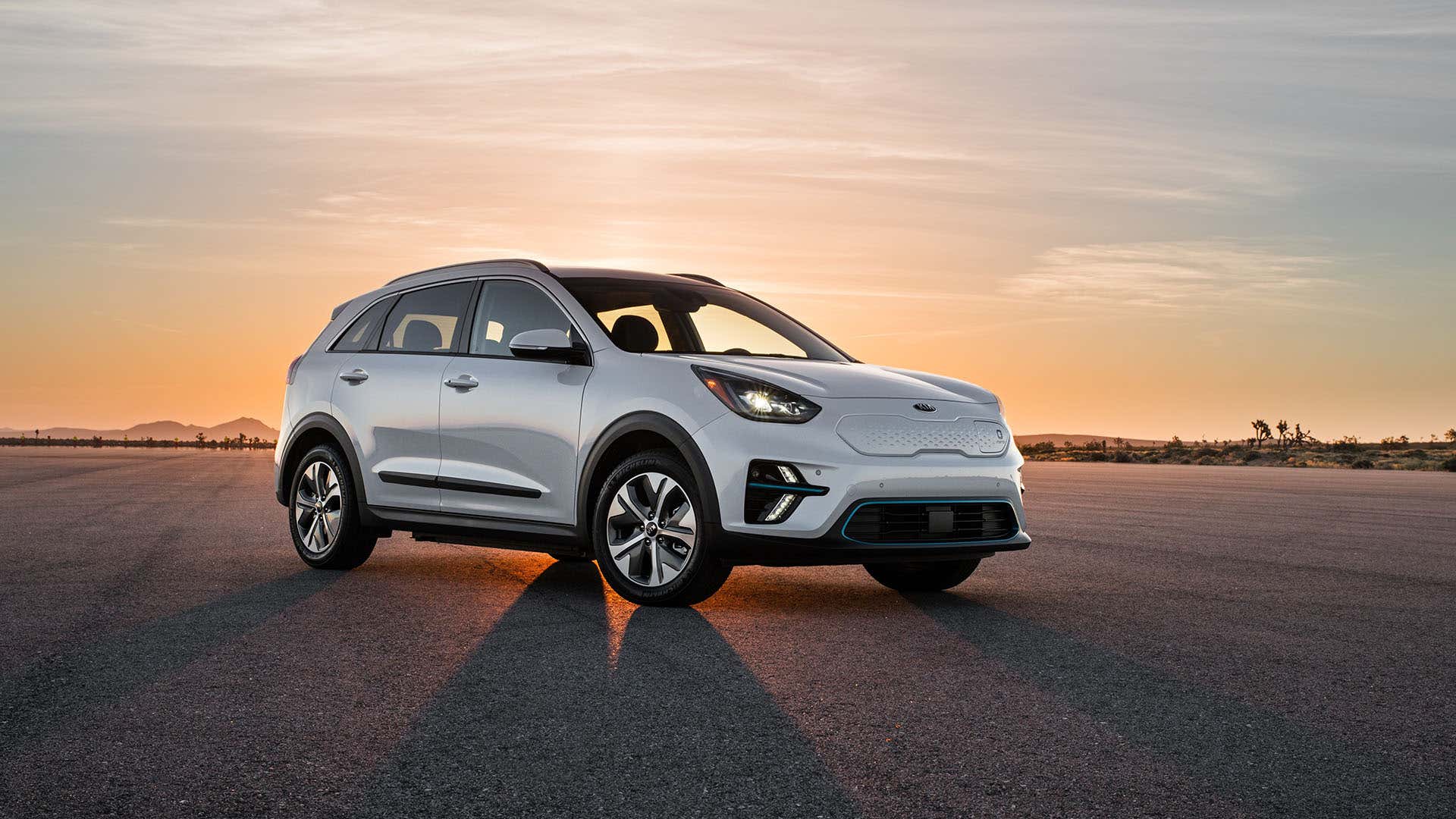 A 2020 Kia Niro PHEV poses in front of a sunset. 一辆2020年的起亚尼罗PHEV在日落前摆造型。