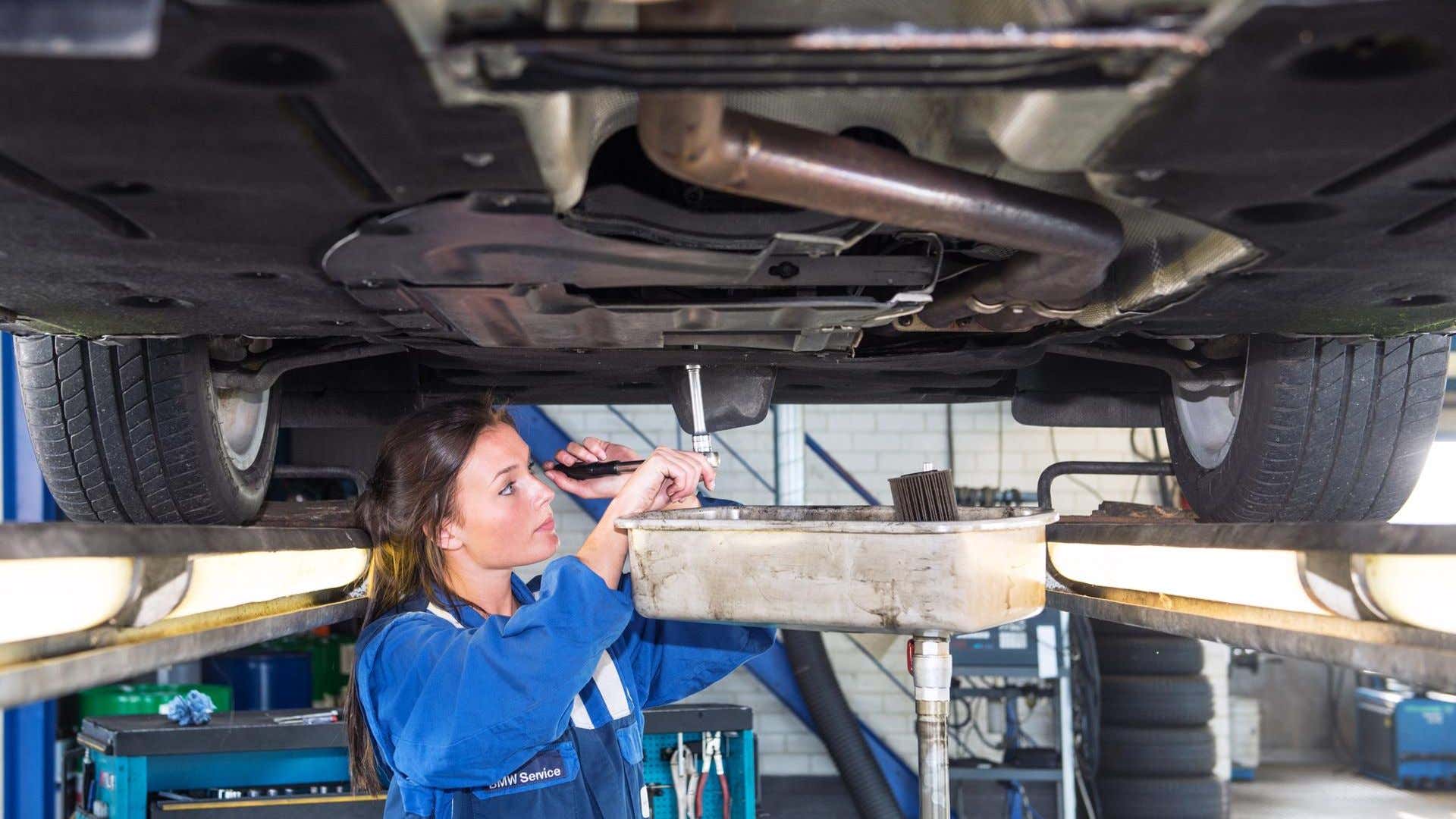 A mechanic performing an oil change. 执行换油的机械师。