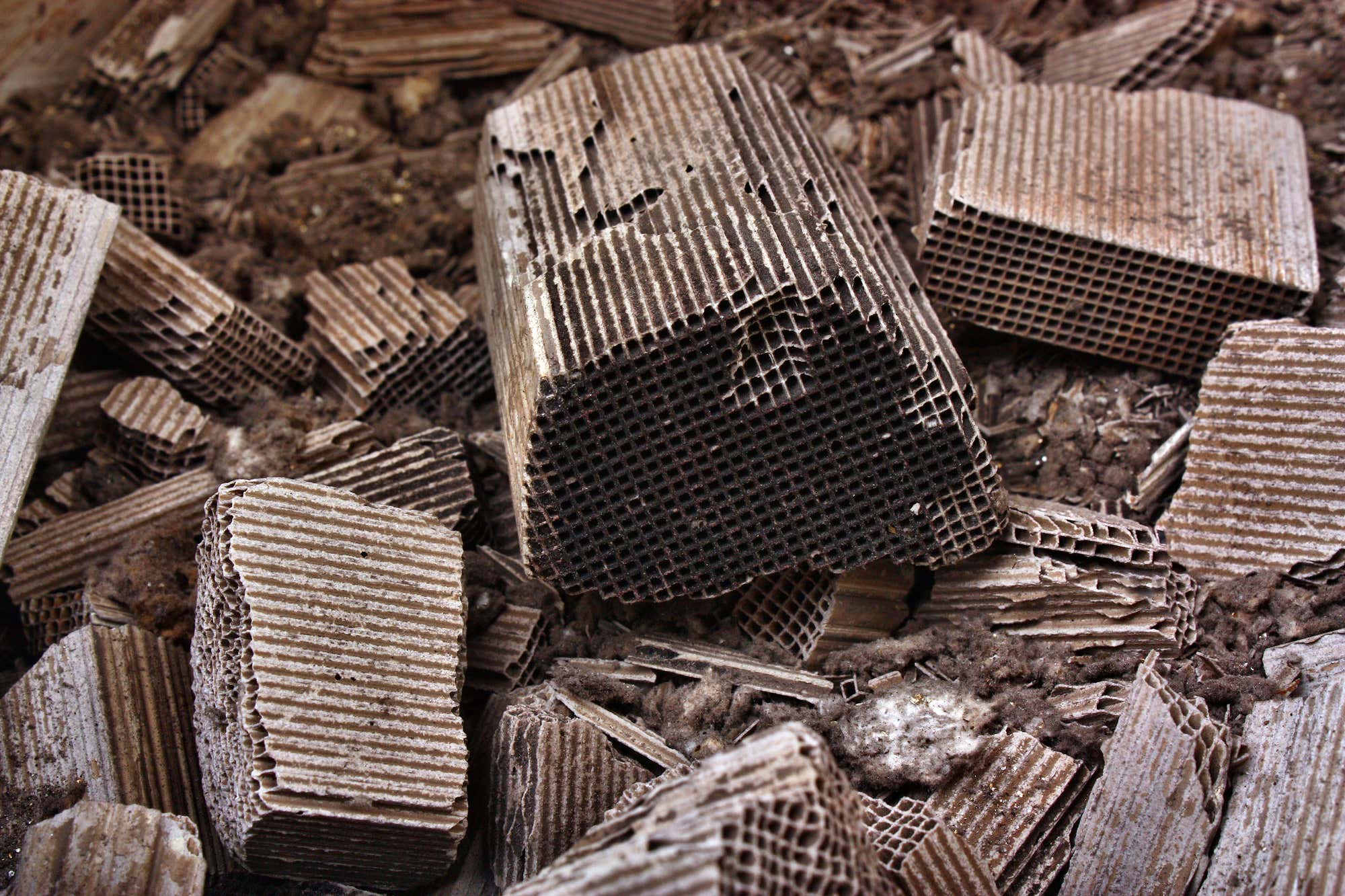 Dirty and broken apart catalytic converter cores in a pile. 桩中的肮脏和破碎的催化转换器核心。