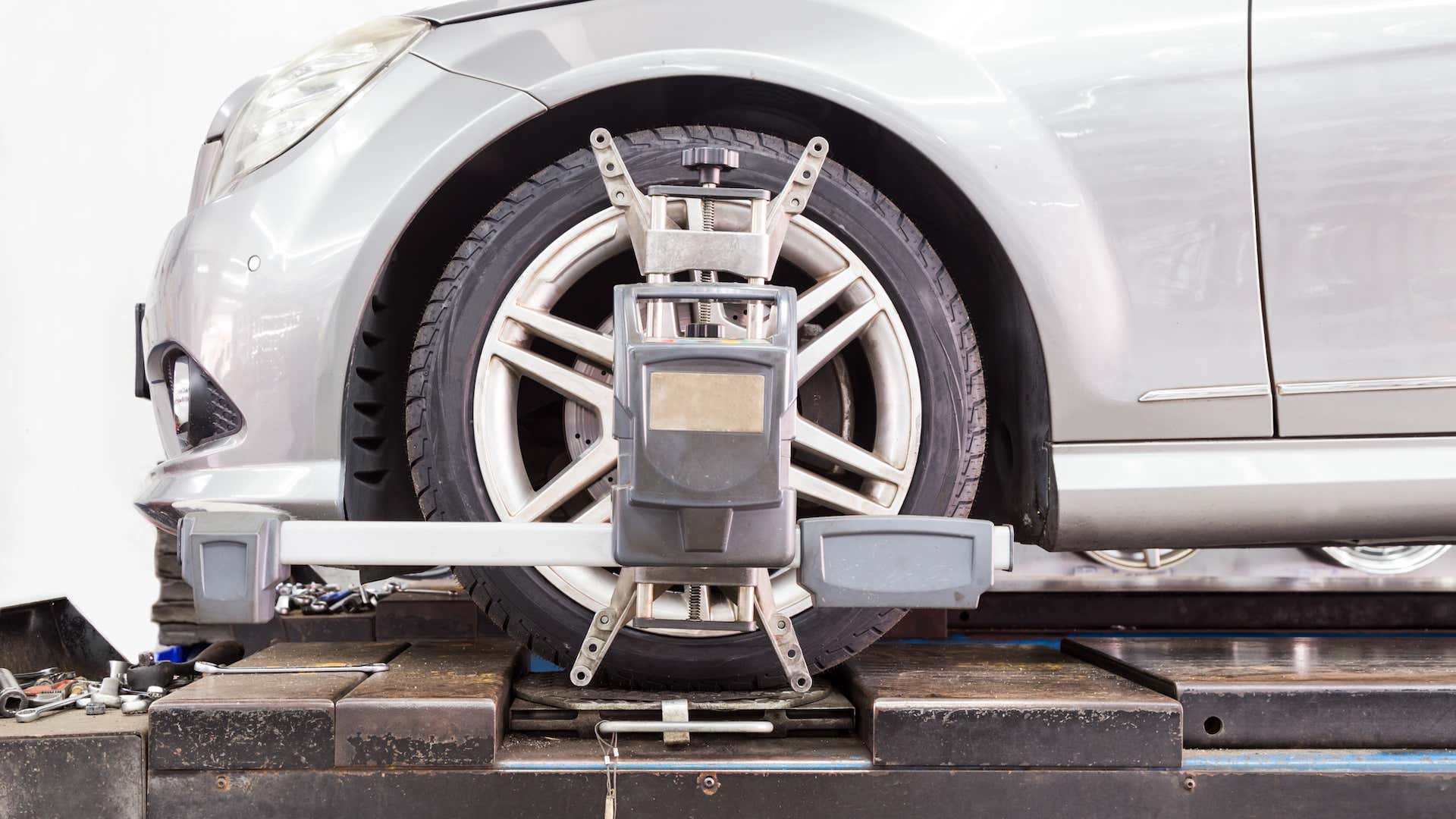 A wheel alignment tool is attached to the front driver's side tire of the car. 车轮对准工具附接到车辆的前驾驶员侧轮胎。