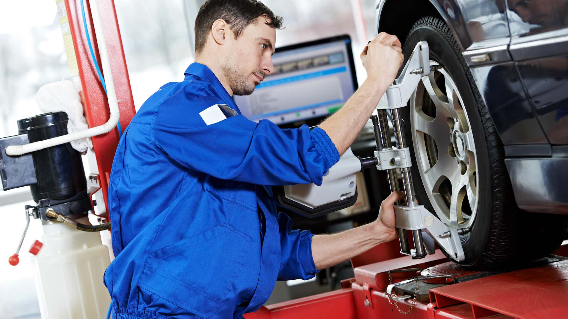 A mechanic sets up a wheel alignment. 一名机械师正在对轮。