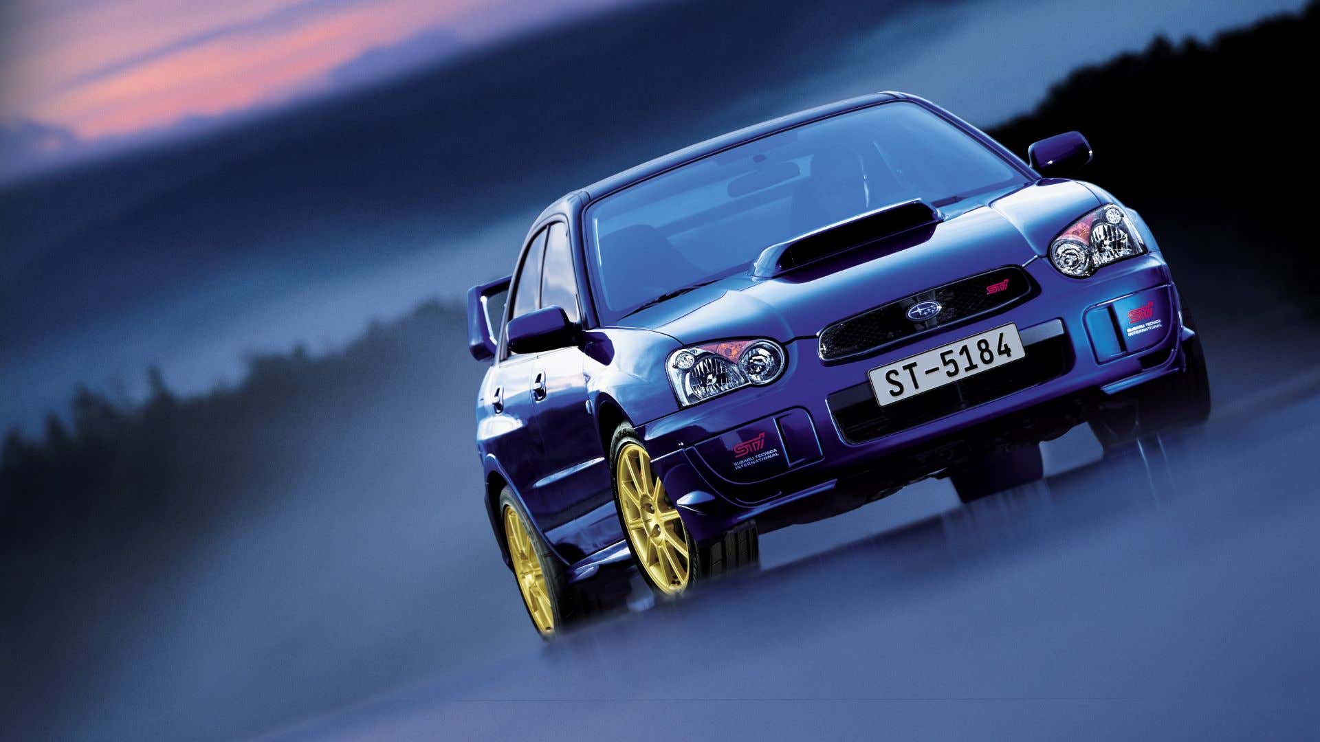 A blue Subaru WRX STI poses with gold wheels. 一辆蓝色的斯巴鲁WRX STI与金色车轮合影。