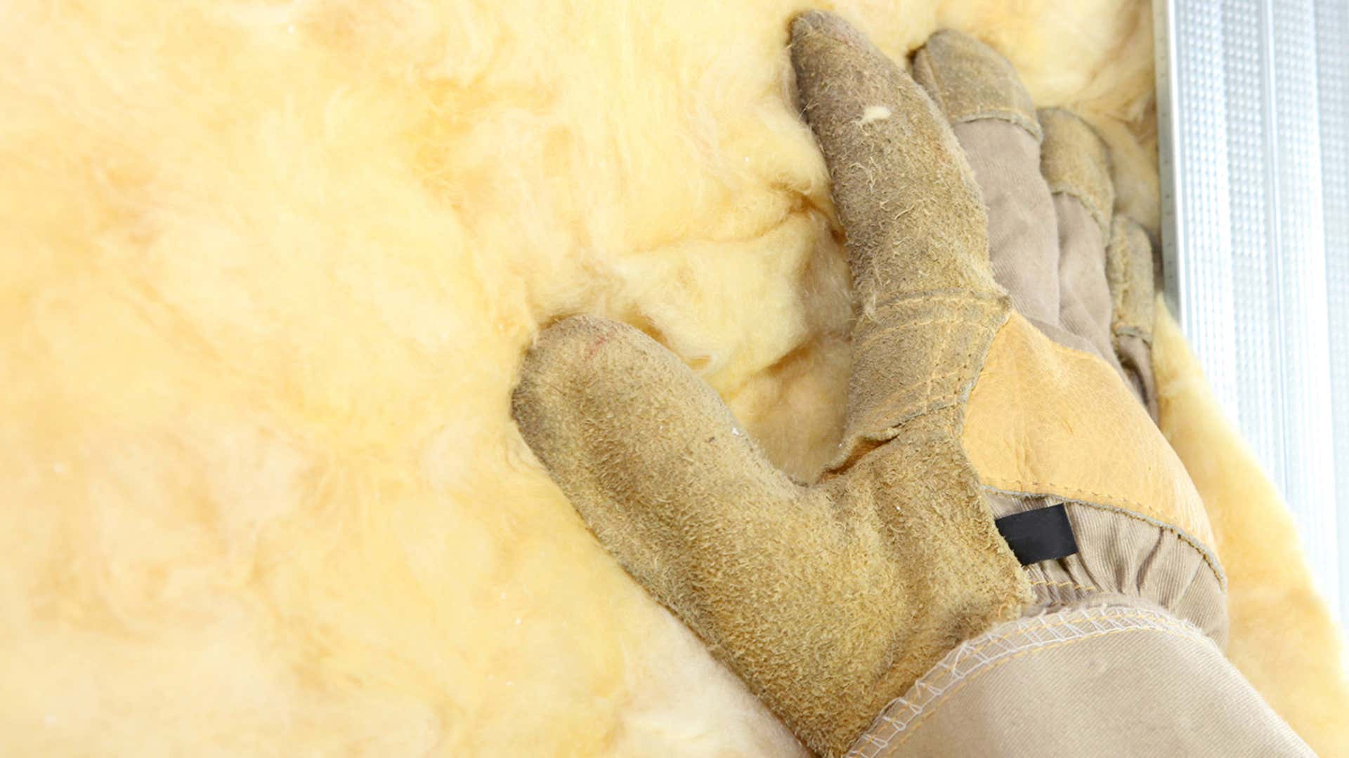 A sturdy work glove pats down insulation. 坚固的工作手套拍拍绝缘。