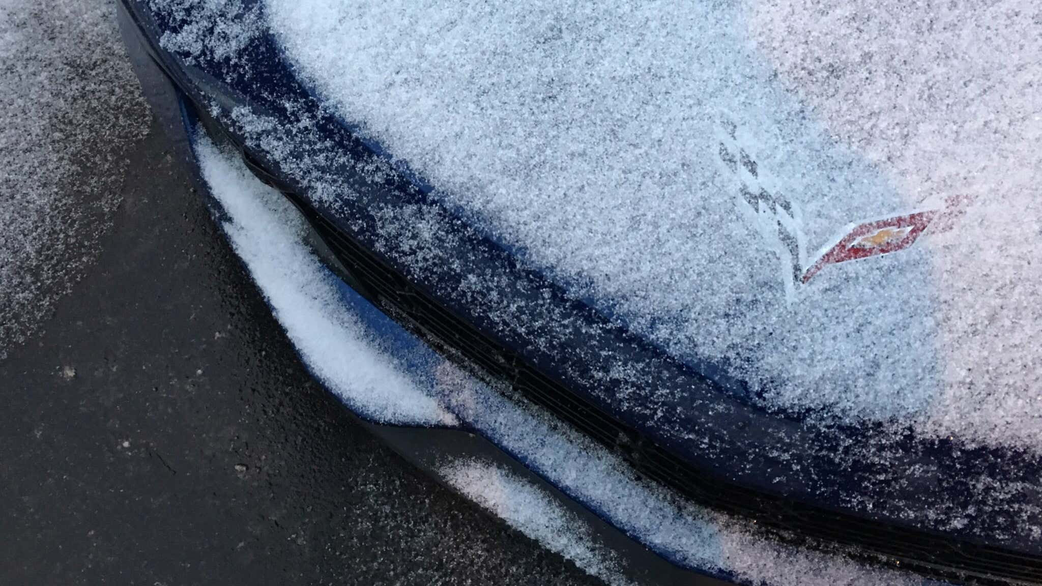 A blue 2019 Corvette Grand Sport sits covered in snow. 一辆蓝色的2019 Corvette Grand Sport被雪覆盖着。