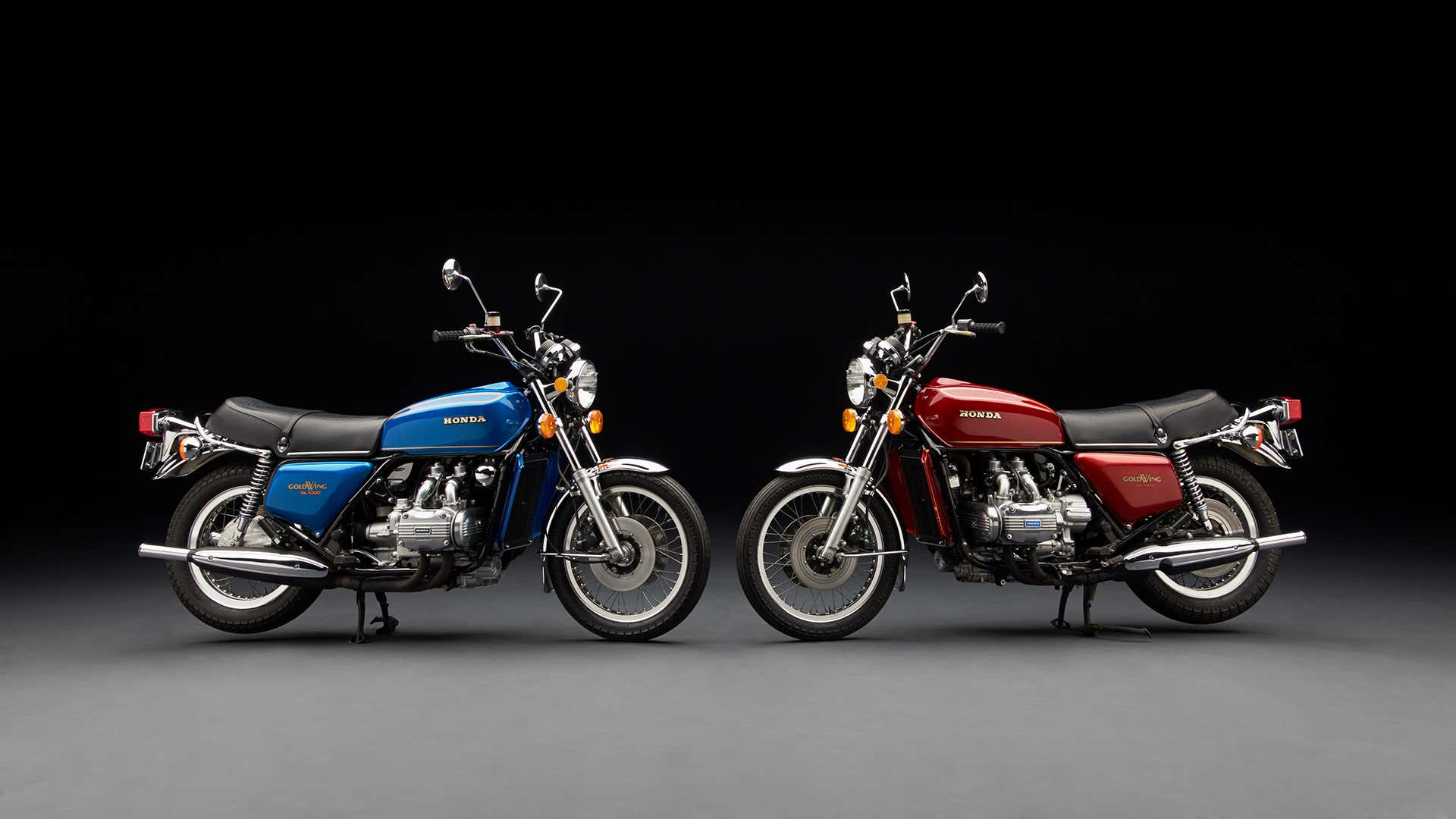 Blue and red vintage Honda Goldwings pose in a studio. 蓝色和红色的老式本田Goldwings造成的工作室。