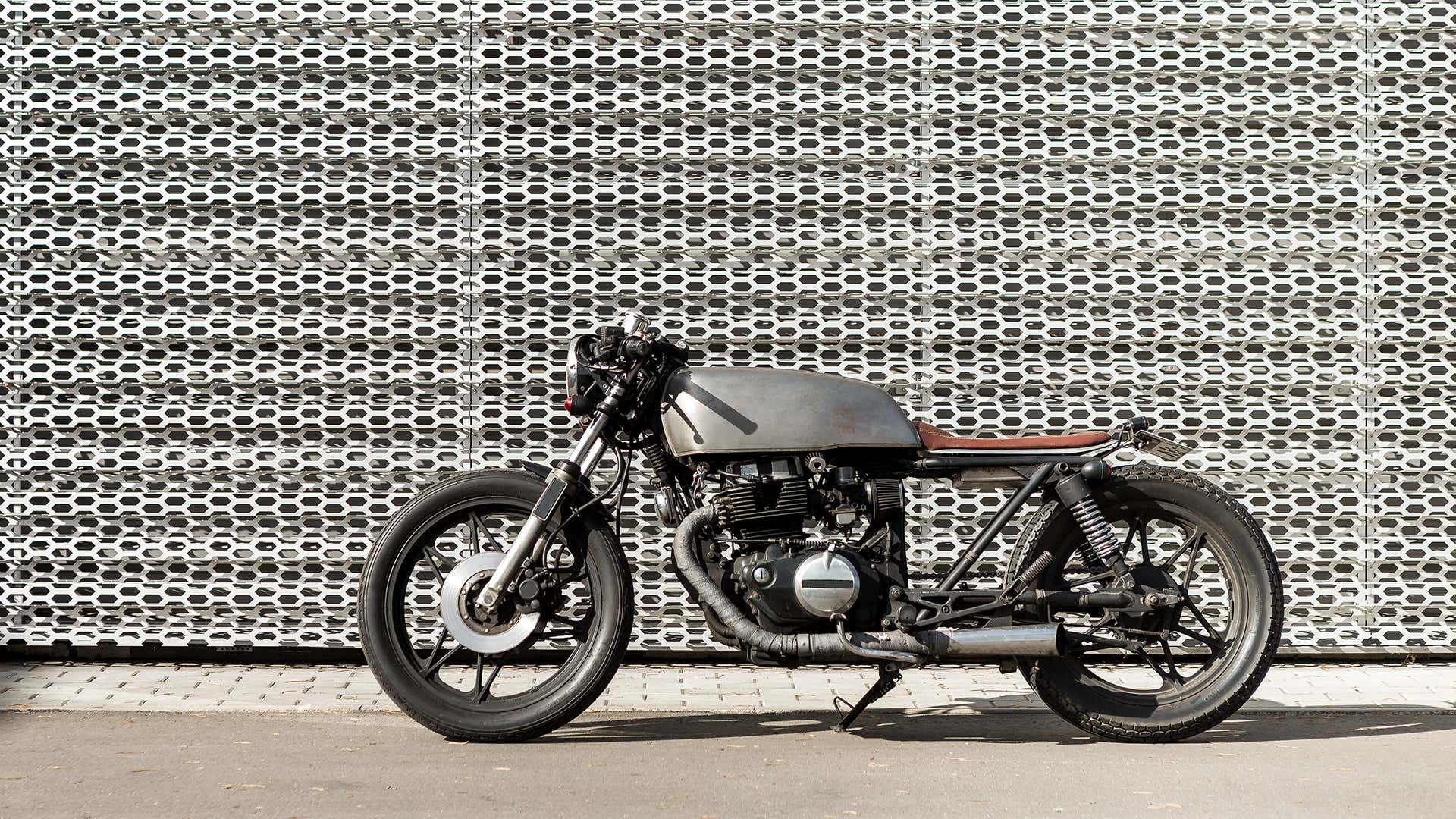 A cafe racer in front of a textured wall. A咖赛车在有纹理的壁的前面。