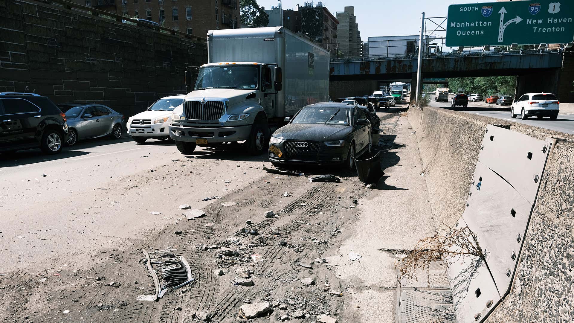 Several cars, trucks, and crossovers are seen on dirty highway after a flood. 洪水过后,在肮脏的公路上可以看到几辆小汽车、卡车和立交桥。