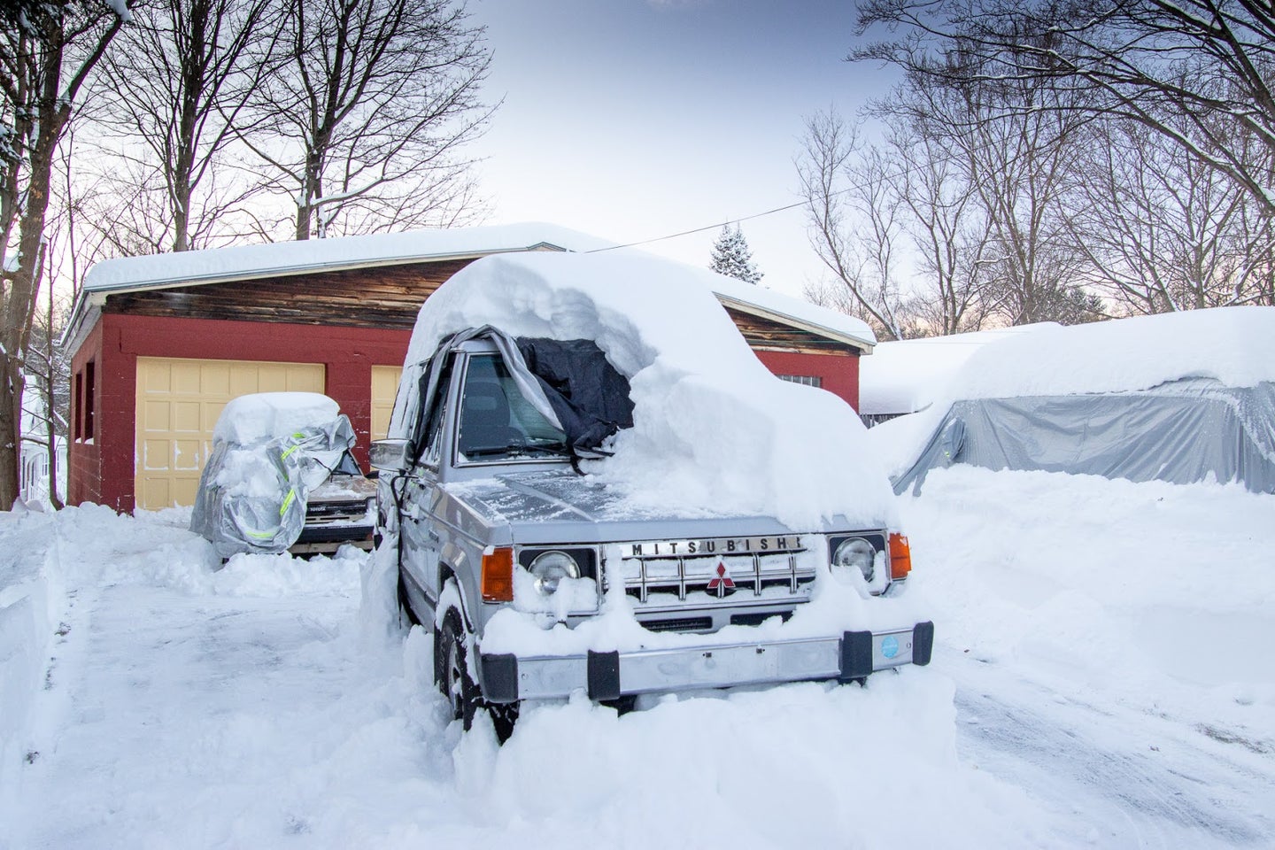 雪地里有汽车罩的汽车