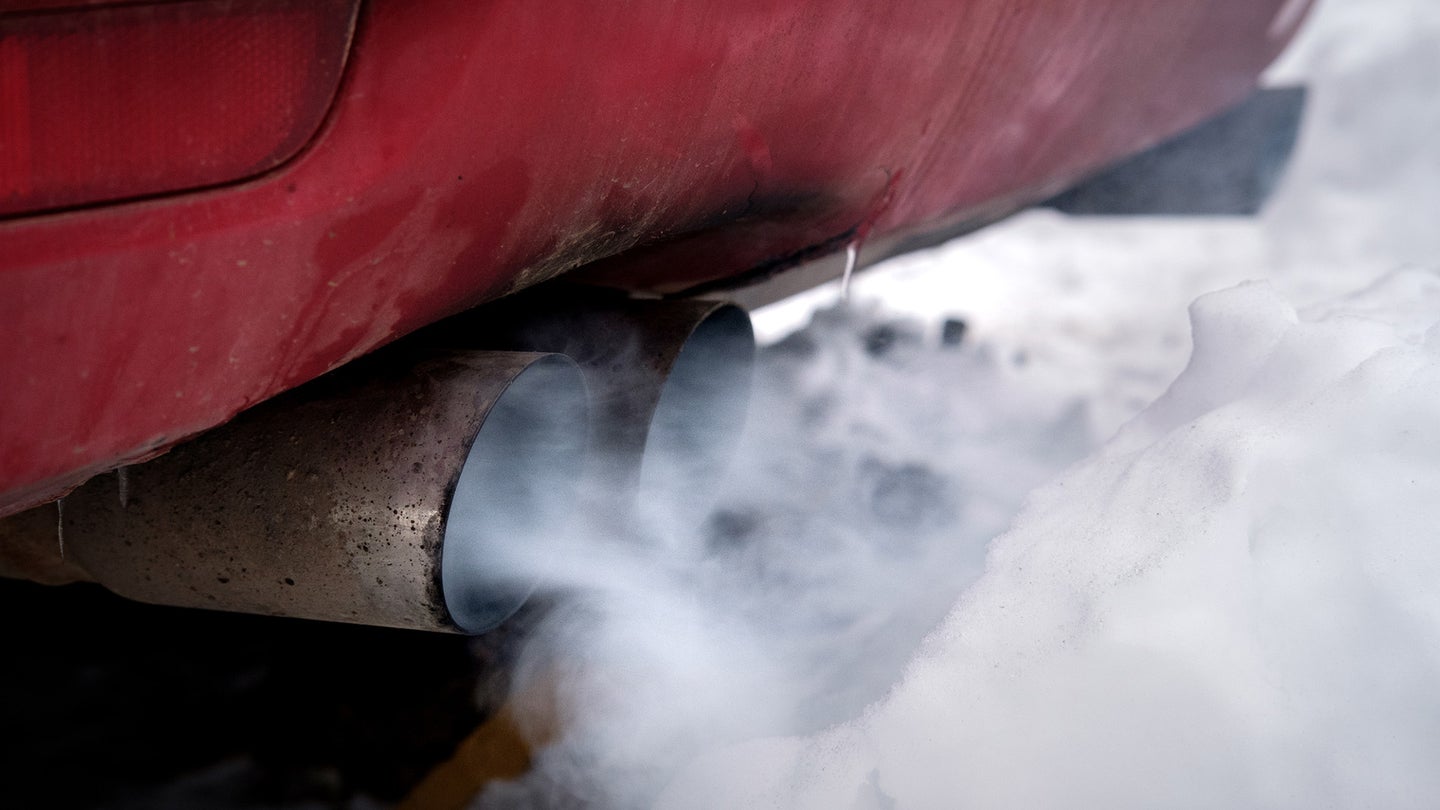 浅白色的烟雾从汽车的排气管中出来。